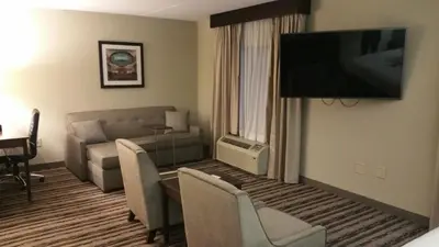 a living room with a couch and a flat screen tv at Holiday Inn Harrisburg East by IHG in Middletown