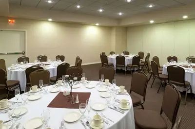 a room filled with tables and chairs with white tablecloths at DoubleTree by Hilton Binghamton in Binghamton