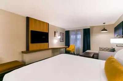 a hotel room with a large bed and a living room at Best Western Premier the Central Hotel & Conference Center in Harrisburg