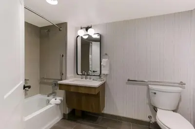 a bathroom with a sink and a toilet and a mirror at Best Western Premier the Central Hotel & Conference Center in Harrisburg