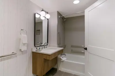 a bathroom with a sink and a tub and a mirror at Best Western Premier the Central Hotel & Conference Center in Harrisburg