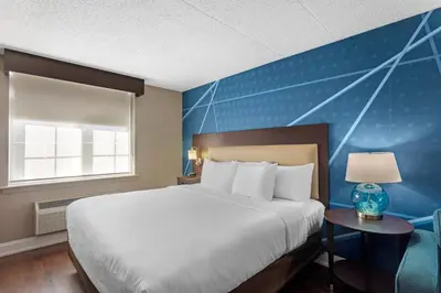 a bedroom with a large bed and a blue wall at Comfort Inn & Suites Pottstown Eastern Gateway in Pottstown