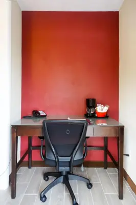 a desk with a chair in front of a red wall at Cocoa Country Inn Hershey in Hershey