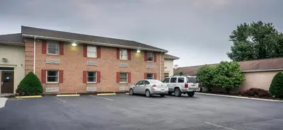 two cars parked in a parking lot in front of a building at Cocoa Country Inn Hershey in Hershey