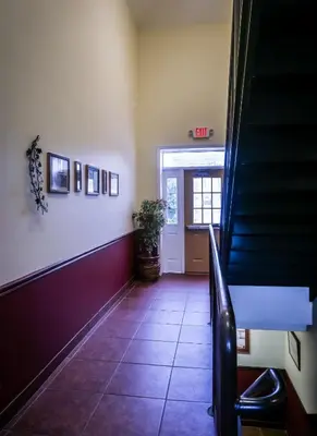 a hallway with stairs and a door with a potted plant at Cocoa Country Inn Hershey in Hershey