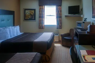 a hotel room with a bed and a chair at Cocoa Country Inn Hershey in Hershey