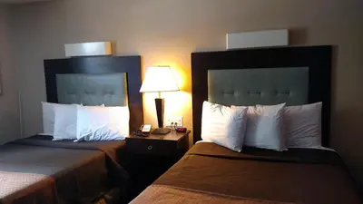 a hotel room with two beds and a lamp at Cocoa Country Inn Hershey in Hershey