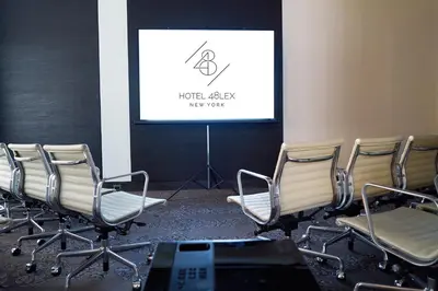 a group of chairs in a room with a screen at Hotel 48LEX New York in New York