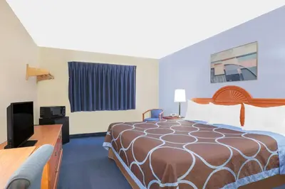 a hotel room with a bed and a flat screen tv at Super 8 by Wyndham Middletown in Middletown