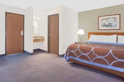 a hotel room with a bed and a door at Super 8 by Wyndham Middletown in Middletown