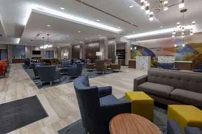 a waiting room with couches and chairs and tables at La Quinta Inn & Suites by Wyndham Middletown-Goshen in Middletown