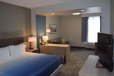 a hotel room with a bed and a desk at La Quinta Inn & Suites by Wyndham Middletown-Goshen in Middletown