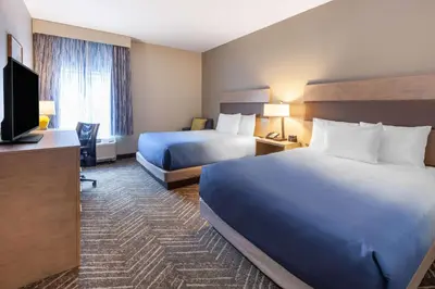 a hotel room with two beds and a flat screen tv at La Quinta Inn & Suites by Wyndham Middletown-Goshen in Middletown