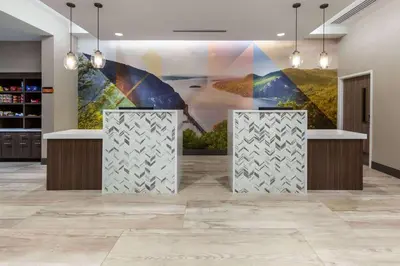 a lobby with a large painting on the wall at La Quinta Inn & Suites by Wyndham Middletown-Goshen in Middletown