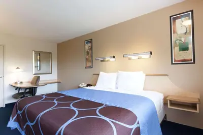 a hotel room with a large bed and a table at Days Inn by Wyndham Monmouth Junction-S Brunswick-Princeton in Monmouth Junction