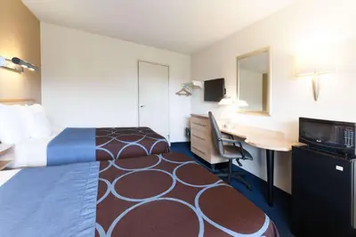 a hotel room with a bed and a desk with a computer at Days Inn by Wyndham Monmouth Junction-S Brunswick-Princeton in Monmouth Junction