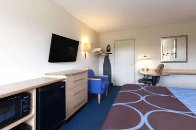 a hotel room with a bed and a desk with a television at Days Inn by Wyndham Monmouth Junction-S Brunswick-Princeton in Monmouth Junction