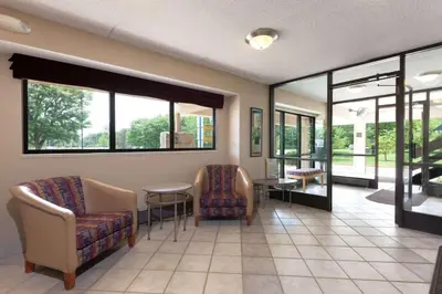 a waiting room with chairs and a table and windows at Days Inn by Wyndham Monmouth Junction-S Brunswick-Princeton in Monmouth Junction