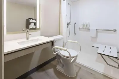 a white bathroom with a toilet and a sink at Ramada by Wyndham Parsippany in Parsippany