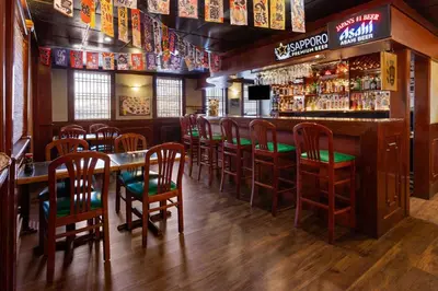 a bar with wooden chairs and a table in a restaurant at Ramada by Wyndham Parsippany in Parsippany