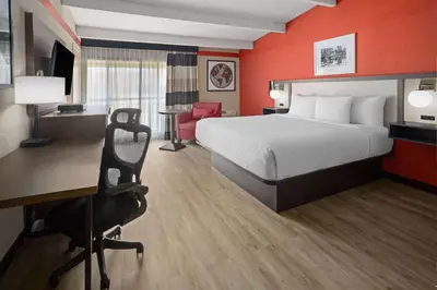 a hotel room with a bed and a desk at Ramada by Wyndham Parsippany in Parsippany