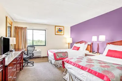a hotel room with two beds and a flat screen tv at Ramada by Wyndham Rockaway in Rockaway