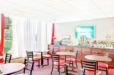 a restaurant with tables and chairs and a counter at Ramada by Wyndham Rockaway in Rockaway