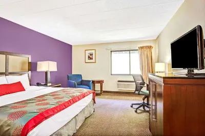 a hotel room with a bed and a flat screen tv at Ramada by Wyndham Rockaway in Rockaway