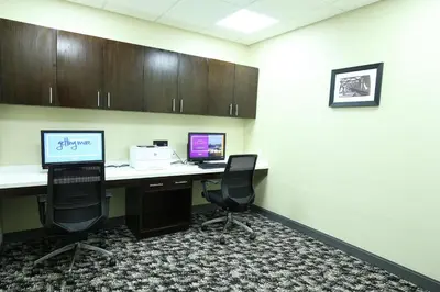 an office cubicle with two computer desks and two chairs at Hampton Inn & Suites Mount Laurel/Moorestown in Mount Laurel