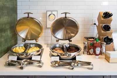 a buffet with three pans of food on a counter at Fairfield Inn & Suites by Marriott Philadelphia Valley Forge/Great Valley in Berwyn