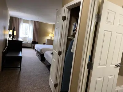 a hotel room with a bedroom with a bed and a door at Days Inn & Suites by Wyndham Manheim Lebanon in Manheim