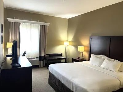 a hotel room with a bed and a television at Days Inn & Suites by Wyndham Manheim Lebanon in Manheim