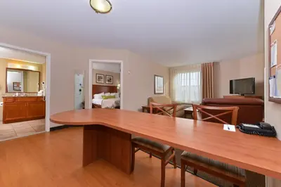 a living room with a large wooden table in a room at Candlewood Suites Elmira Horseheads by IHG in Horseheads