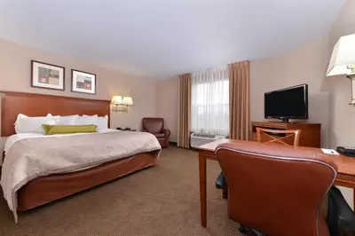 a hotel room with a bed and a desk at Candlewood Suites Elmira Horseheads by IHG in Horseheads