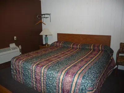 a bed in a hotel room with a colorful bedspread at Red Rose Motel in Elizabethtown