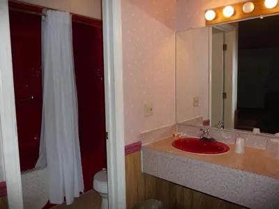 a bathroom with a sink and a toilet and a mirror at Red Rose Motel in Elizabethtown