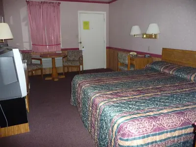 a hotel room with a bed and a flat screen tv at Red Rose Motel in Elizabethtown