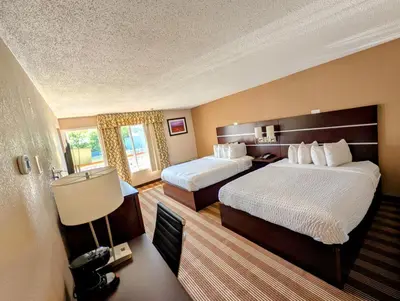 a hotel room with two beds and a lamp at Pocono Inn & Banquet - Stroudsburg in Delaware Water Gap