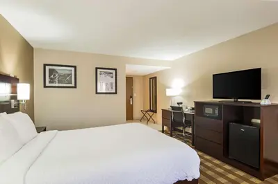 a hotel room with a bed and a flat screen tv at Pocono Inn & Banquet - Stroudsburg in Delaware Water Gap