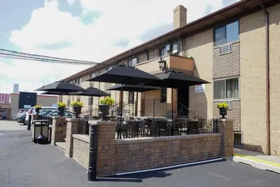 a restaurant with tables and umbrellas in front of a building at Holland Hotel Free Parking Jersey City in Jersey City