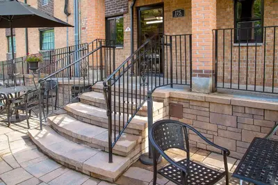 a set of stairs leading up to a building with tables and chairs at Holland Hotel Free Parking Jersey City in Jersey City