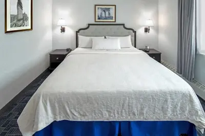 a large bed in a hotel room with two night stands at Holland Hotel Free Parking Jersey City in Jersey City