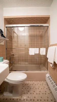 a bathroom with a shower with a toilet and a sink at Holland Hotel Free Parking Jersey City in Jersey City