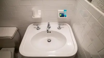 a bathroom with a white sink and a toilet at Holland Hotel Free Parking Jersey City in Jersey City