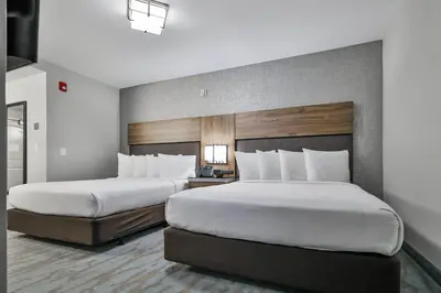 a hotel room with two beds with white pillows at The Penn Stroud, Stroudsburg - Poconos, an Ascend Collection Hotel in Stroudsburg