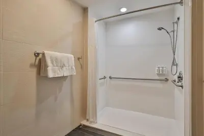 a bathroom with a shower with a glass door at The Penn Stroud, Stroudsburg - Poconos, an Ascend Collection Hotel in Stroudsburg