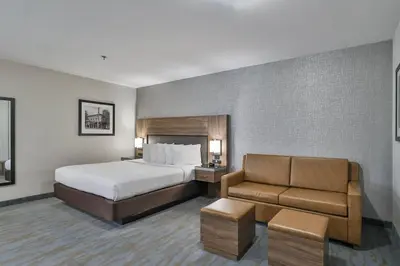 a hotel room with a bed and a couch at The Penn Stroud, Stroudsburg - Poconos, an Ascend Collection Hotel in Stroudsburg