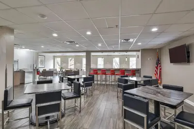 a dining room with tables and chairs and a flag at The Penn Stroud, Stroudsburg - Poconos, an Ascend Collection Hotel in Stroudsburg