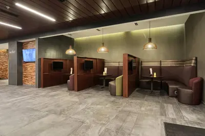 a waiting room with couches and tables and televisions at Courtyard by Marriott North Brunswick in North Brunswick