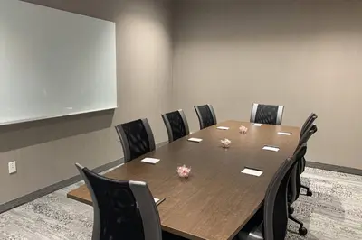 a conference room with a wooden table and chairs at Courtyard by Marriott North Brunswick in North Brunswick